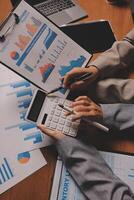Business people working on a calculator and papers photo