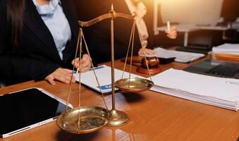 Two business people sitting at a table with a scale of justice photo