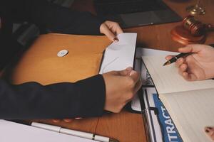 Two people are signing documents at a desk photo