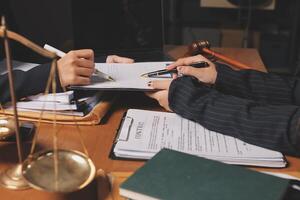 Two people sitting at a desk with a scale and a pen photo