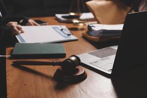Lawyer and judge sitting at a desk with a laptop and a gavel photo