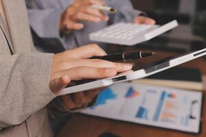 Business people using a tablet and pen to write on a paper photo