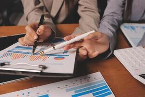 Business people working on a document with a pen and calculator photo