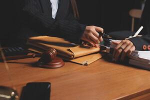 Two business people sitting at a desk with a gavel and papers photo