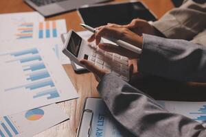 Business people working on a calculator and papers photo