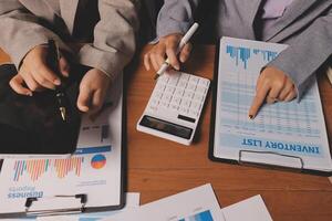 Business people working on paperwork and a calculator photo
