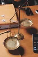 A scale of justice on a desk with a calculator and papers photo