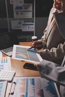 A woman is sitting at a desk with a laptop and a paper photo