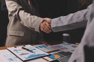 Two business people shaking hands over a desk photo