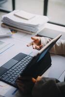 A person using a laptop and a tablet on a desk photo