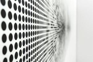 A close-up of a modern art piece featuring a pattern of black dots radiating outward on a white background. photo