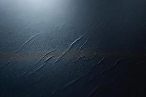 Close-up of textured dark surface with subtle grooves and a soft light reflection. photo
