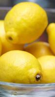 Glass bowl lemon fresh lemons in a glass bowl at a bar, with a variety of bottles in the background, capturing a vibrant and refreshing scene in 4K slow motion 120fps video