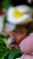 Professional chef carefully cutting boiled eggs over colorful tomato potato salad, showcasing precise culinary techniques in elegant slow motion video