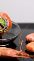 shrimp sushi hand pouring soy sauce while picking up sushi with chopsticks. Sushi bar concept. video
