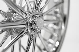 Close-up of a shiny chrome car wheel, showcasing intricate spokes and a polished surface. photo
