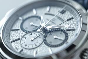 Close-up of an intricate men's chronograph watch with a textured white dial and silver-toned accents. photo