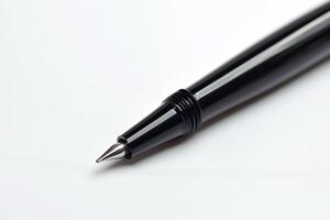 Close-up of a sleek black pen highlighting its precision tip against a clean white background. photo