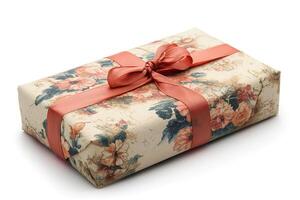 An elegantly wrapped gift featuring floral patterned paper and a soft coral ribbon bow. photo