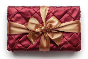 A beautifully wrapped gift in deep red satin with a gold ribbon, perfect for any festive occasion. photo