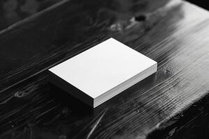 A clean stack of blank business cards on a dark wooden surface, creating an elegant minimalist aesthetic. photo
