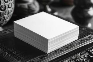 A stack of pristine blank business cards on an ornate dark wood surface, perfect for customization. photo