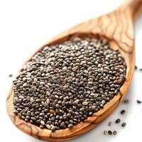 A close-up of black chia seeds in a wooden spoon, emphasizing their texture and nutritional appeal. photo