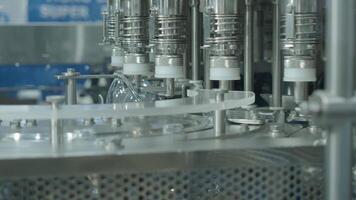 Close up view of a plastic bottle production line in a factory. Parts of transparent PET bottles move along an automated conveyor system. Showing modern PET drinking bottles manufacturing automation. video