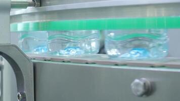 Close up view of a plastic bottles production line in a factory. Parts of transparent PET bottles move along an automated conveyor system. Showing modern PET drinking bottles manufacturing automation. video