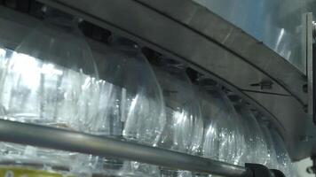 Close up view of a plastic bottle production line in a factory. Parts of transparent PET bottles move along an automated conveyor system. Showing modern PET drinking bottle manufacturing automation. video
