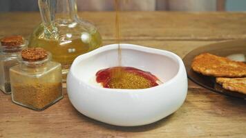 In plates of sauce, based on mayonnaise, ketchup, and sour cream, powdered curry seasoning is added, giving the dish a spicy taste. video