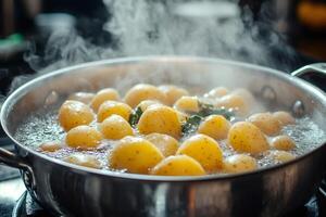 Small potatoes boiling in a pot with herbs and steam rising photo