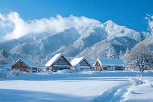 Gassho-style farmhouses standing in snowy fields with Mount Dainichi rising in the background in Shirakawa-go, Japan photo