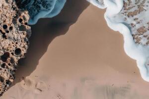 Waves gently wash over smooth sandy shorelines near a textured rock photo
