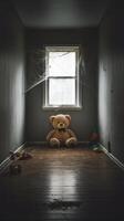 A teddy bear sits in an empty room photo