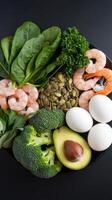 A plate with eggs, spinach, broccoli, and shrimp photo