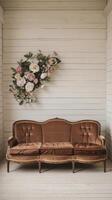 A vintage couch with flowers hanging from the wall photo