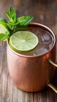 Moscow mule alcoholic cocktl in copper mug with lime ginger beer vodka and mint photo