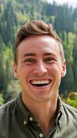 A man smiles while standing in front of a forest photo