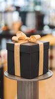 A black gift box sitting on top of a table photo