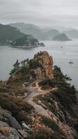 A scenic view of the ocean and mountains from a rocky cliff photo