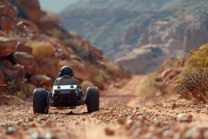A person driving a remote control car on a dirt road photo
