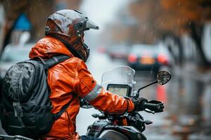 A person in an orange jacket riding a motorcycle in the rain photo