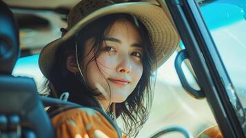 A woman in a hat driving a car photo
