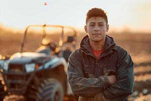 A young man standing in front of a tractor photo