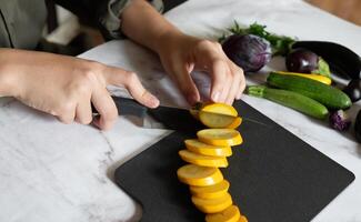 Slicing zucchini on a cutting board On a sunny day on a gray background. Top view, horizontal. photo