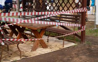 Slide on empty playground in park fenced with red and white attention tape during COVID 19 epidemic photo