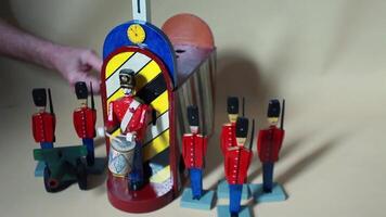 The drummer is drumming next to the brave guards with a cannon, a man is turning the handle, an automaton with sound video