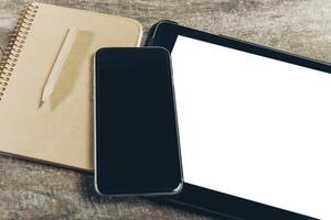 Close up of smartphone with notepad and drink on grunge wooden background photo