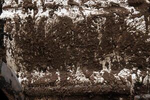 Closeup of a mud covered vehicle surface showing thick dirt layers, symbolizing offroad adventure, extreme terrain, and rugged outdoor experiences. Detailed textured view of muddy car photo